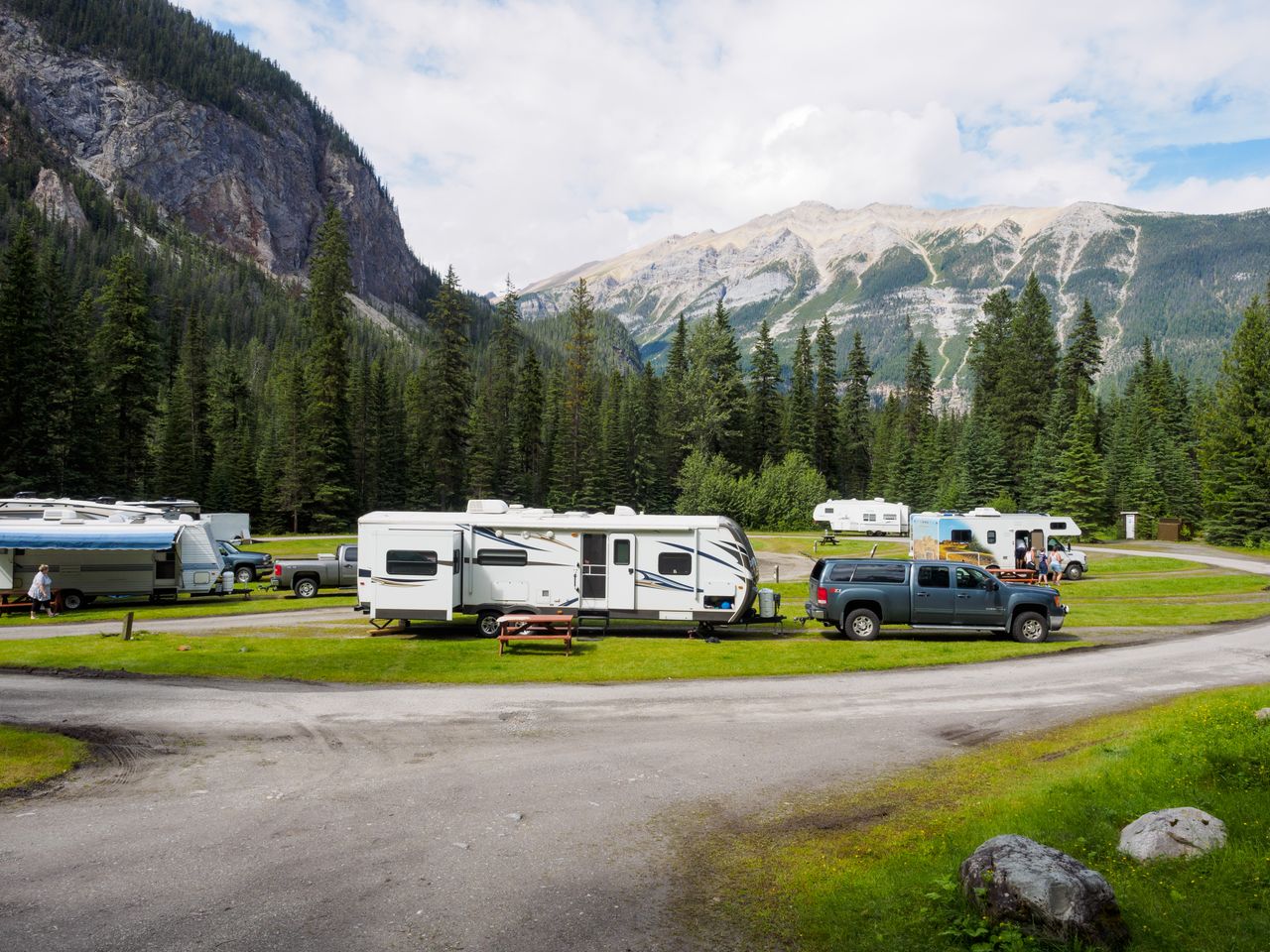 Mastering the First Impression: Your intriguing post title goes here A beautiful campsite featuring RVs amidst lush forests and towering mountains for a peaceful getaway.