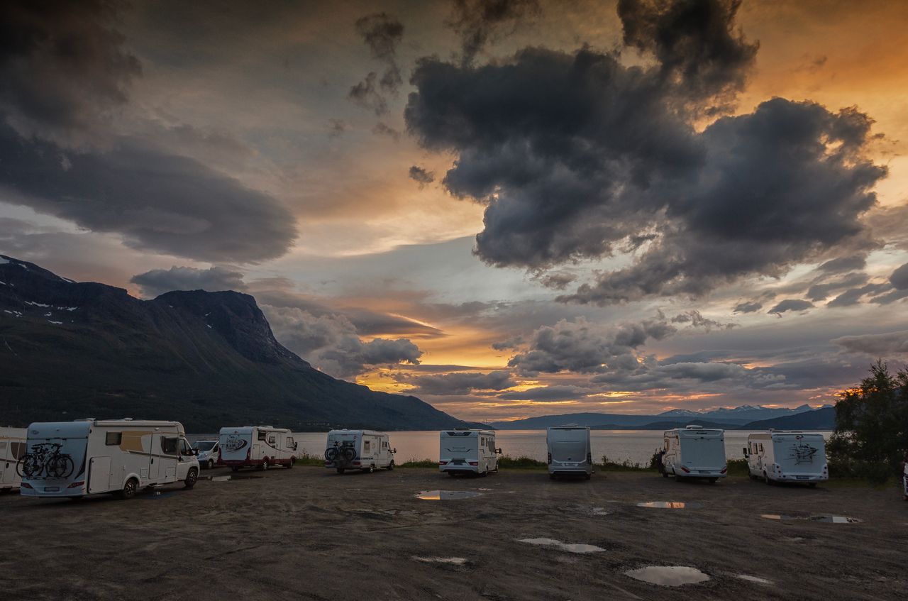 The Art of Drawing Readers In: Your attractive post title goes here Stunning sunset view over a scenic Norwegian campsite with parked RVs and dramatic clouds.